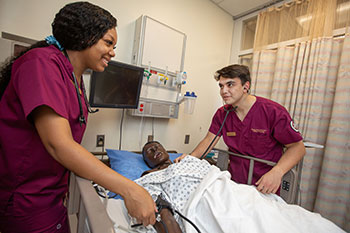 Photo of nursing students practicing on a dummy. Links to Gifts That Protect Your Assets