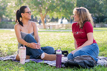 Photo of students sitting outside. Links to Gifts from Retirement Plans